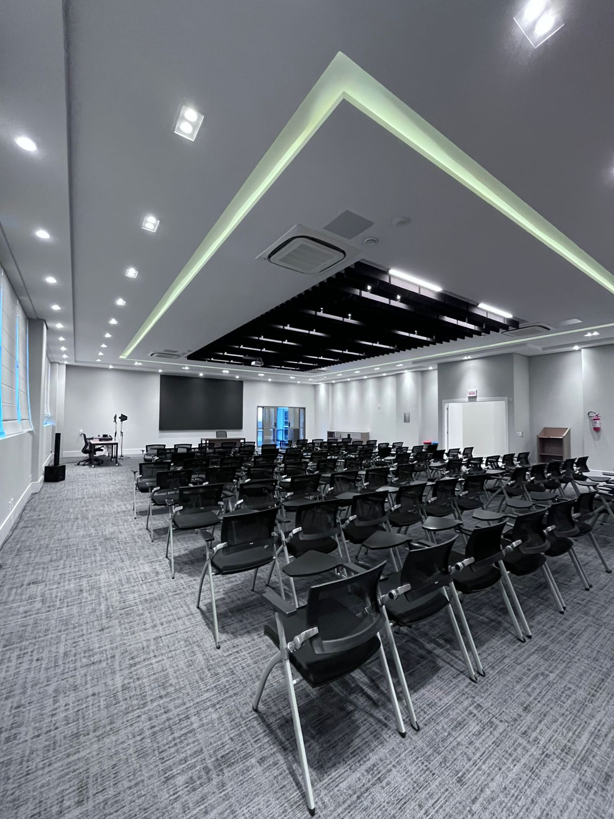 Auditório do evento com cadeiras em formato de plateia e telão